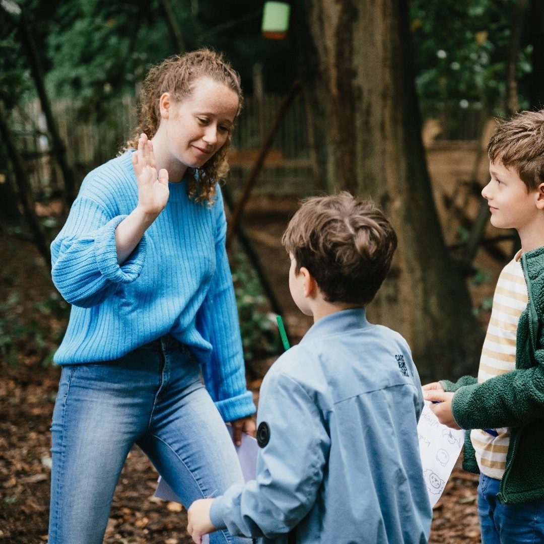 Vrouw geeft jongen op BSO high-five